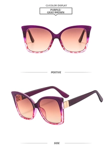 Detail of cat eye sunglasses featuring purple gradient frames and gold metal hinge accents