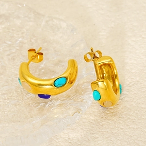 Detailed view of vintage gold C-shape earrings with turquoise and gemstone inlays