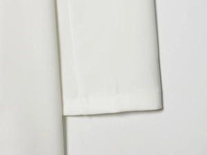 Close-up of white dress fabric showing high-density plain weave and precise stitching