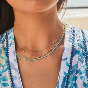 Bohemian style triple layer gold necklace set with turquoise pendant shown on a model