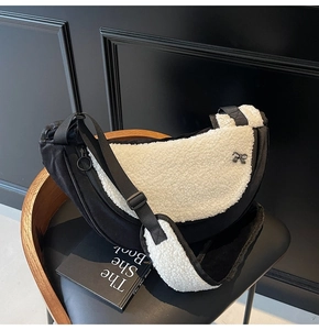 Detail of contrast shearling crescent bag featuring silver bow and adjustable strap