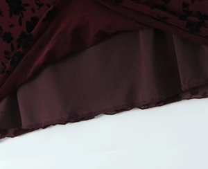 Detailed macro view of burgundy floral mesh lace with high-quality stitching on dress