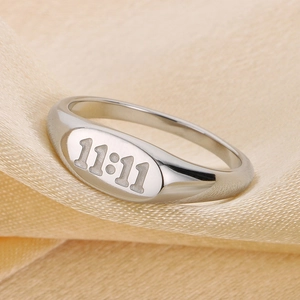 Macro shot of silver stainless steel signet ring with engraved 11:11 angel numbers