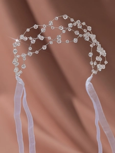 Detailed close-up of handmade beaded crystal headband with elegant white chiffon ribbon ties