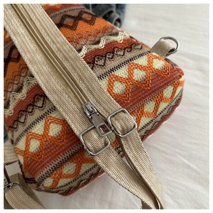 Detailed close-up of ethnic geometric pattern fabric and metal zipper on backpack