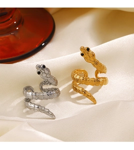 Macro shot of gold and silver snake rings with scale texture on silk background