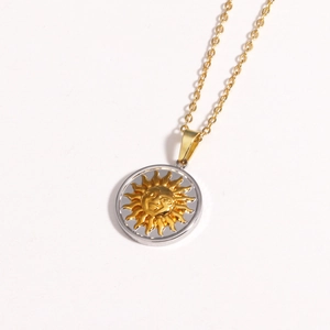 Close-up of golden sunflower pendant with silver outer rim on titanium steel chain
