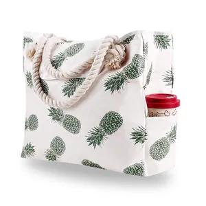 Detail of canvas tote bag with pineapple print, rope handles and functional side pocket