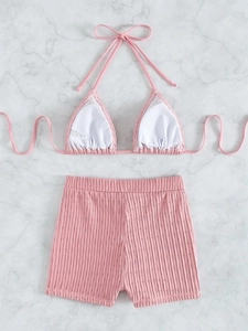Detail of mauve ribbed bikini fabric showing knit texture and hollow dot pattern