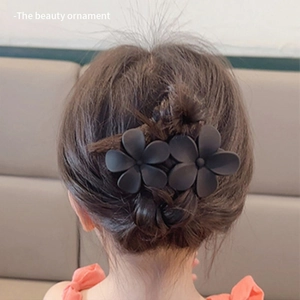 Detail of matte black flower hair claw clip worn by a model for elegant back hair styling