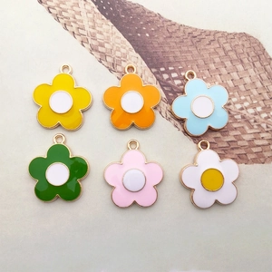 Close-up of colorful enamel flower pendants in alloy with golden metal edges for DIY jewelry