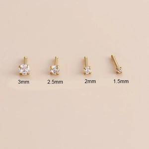 Detail of four gold vacuum plated stainless steel nose studs with zircons in various sizes