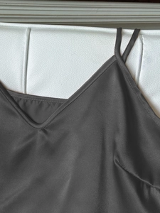Détail d'un caraco en satin gris anthracite avec col en V et fines bretelles