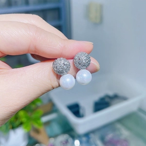 Macro shot of s925 silver needle pearl earrings with micro-inlaid zircon sphere detail