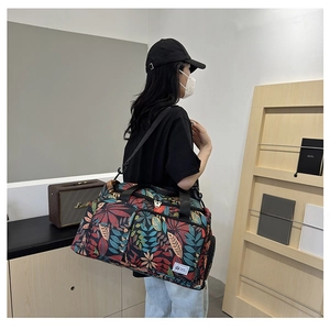 Detail of travel tote bag with colorful leaf patterns and adjustable shoulder strap