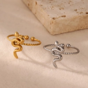 Detailed close-up of gold and silver snake rings with textured scales on stone