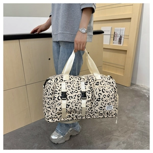 Large leopard print travel bag shown by model featuring a separate side shoe pocket