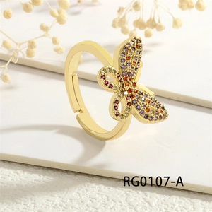 Detail view of gold butterfly open ring with multi-color zircon inlay on white surface