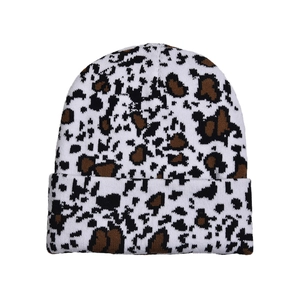 Macro detail of cow print pattern on a thick cuffed knit beanie with leopard texture