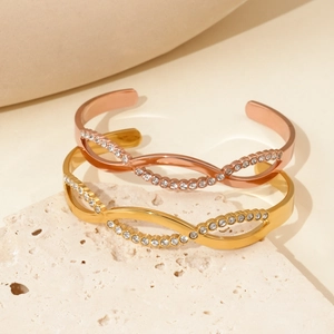 Elegant C-shaped twisted stainless steel bracelets with sparkling crystals in gold and rose gold