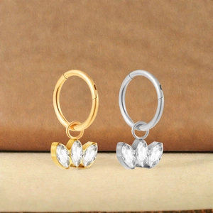 Close-up of titanium nose rings with marquise-cut zircon crown pendants in gold and silver