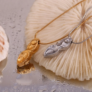 Vue détaillée de pendentifs cacahuète en or 18 carats et argent aux textures réalistes