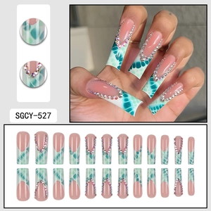 Long coffin fake nails set featuring nude pink base, green marble patterns and rhinestones