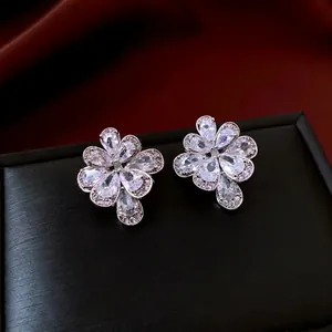 Elegant silver flower drop earrings with sparkling zircon stones on luxury velvet