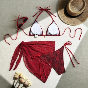 Detailed flat lay of red lace three-piece bikini set with matching floral mesh skirt