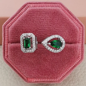 Detailed view of emerald stud earrings in a pink velvet box with shiny silver settings