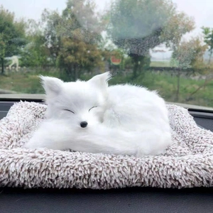 Detailed close-up of a realistic white plush fox sleeping on a cushion in a car