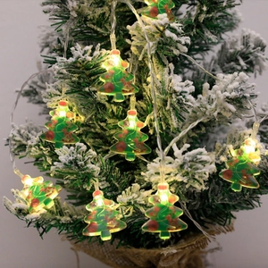 LED Christmas tree string lights with warm yellow glow on snowy pine branches