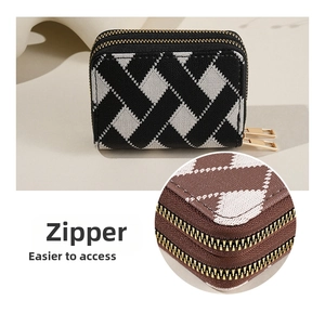 Close-up of double golden zippers and argyle pattern on a compact striped wallet
