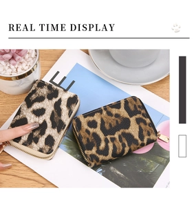Close-up of leopard print card holders with gold zippers on a coffee table setup