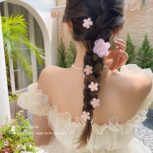 Pink cherry blossom hair clip set with tulle floral design worn by a girl outdoors