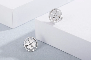 Detail of silver clover earrings featuring hollow geometric design and tiny rhinestones