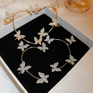 Close-up of gold and silver butterfly ear cuffs with rhinestones in a gift box