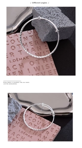 Close-up of silver hammered texture bangle showing light reflection and adjustable opening