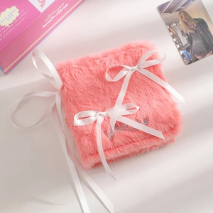 Detailed view of pink plush photocard binder with white silk bow and Jisocute embroidery