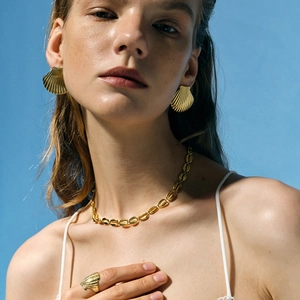 Model wearing golden shell jewelry set with starfish charm necklace and seashell earrings