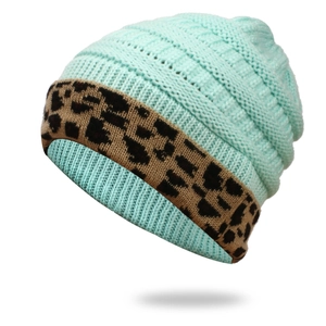Detailed knit texture of mint green winter hat with leopard print fold-over cuff