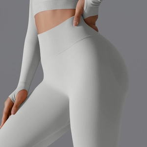 Detail of high waist ribbed waistband and seamless grey yoga pants with thumb hole sleeve