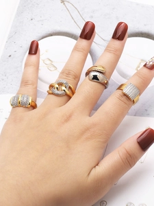 Close-up of stylish gold and silver zircon rings on model's hand with jewelry tray
