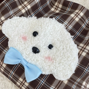 Close-up of cute puppy embroidery with blue bow on textured plaid shoulder bag