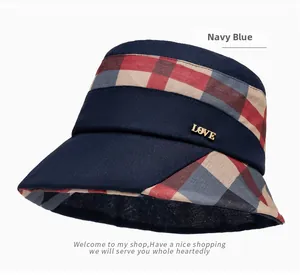 Detail of navy blue plaid bucket hat featuring a gold LOVE metal emblem and sun protection