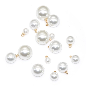 Detailed macro view of white ABS imitation pearl pendants with gold metal rings for DIY jewelry