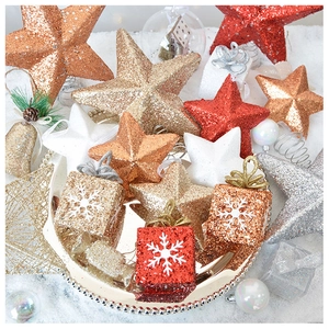 Close-up of sparkling star and gift box Christmas ornaments in a tray with snow