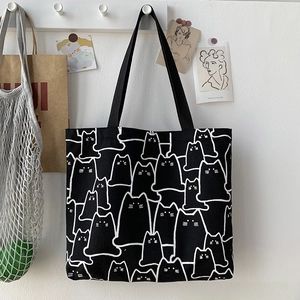 Detail of cute cat pattern print on black canvas tote bag with shoulder straps