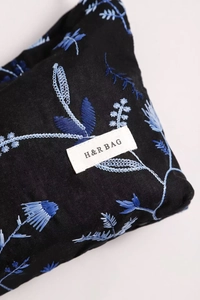 Detail of floral embroidery on black canvas cosmetic bag with H&R BAG woven label