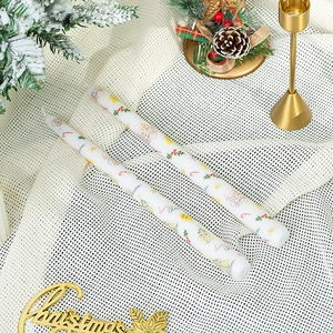 Détail de bougies de Noël coniques avec motifs de Père Noël sur support doré